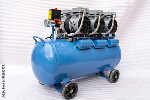 Perspective view of multiple industrial oil-free air compressor pump heads in a row, featuring black cooling fan guards, intake filters, and gray motor housings