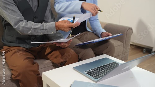 Business team analyzing documents, graphs, and data with a laptop, tablet, and smartphone. Collaboration, strategy, and success in a modern office.