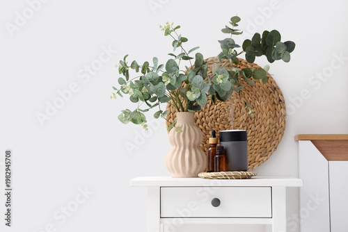 Fotografie Air humidifier, essential oils and vase with eucalyptus on table in bedroom