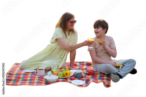 Woman and son having picnic on blanket. Mother and child drinking juice outdoors. Family leisure, summer weekend, healthy food and fruit. Happy lifestyle, outdoor recreation concept.