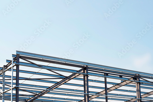 Canvas Print Steel framework builds structure under blue sky at construction site in daylight