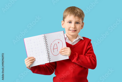 Happy schoolboy holding not...