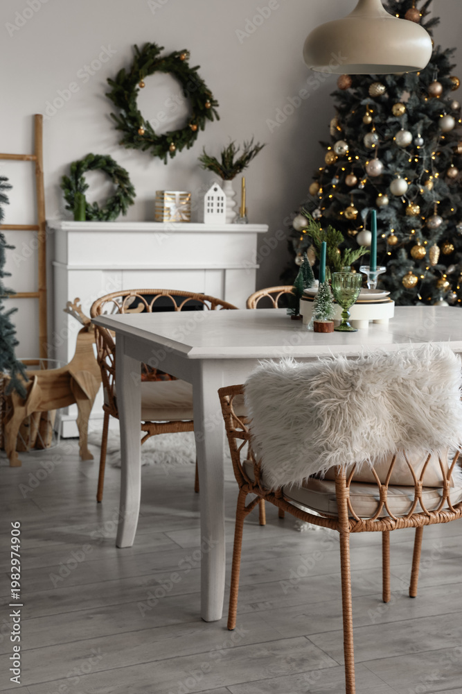 Obraz premium Interior of light dining room with table, fireplace and Christmas tree