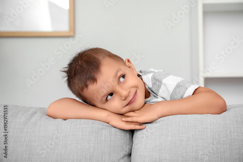 Thoughtful little boy leani...
