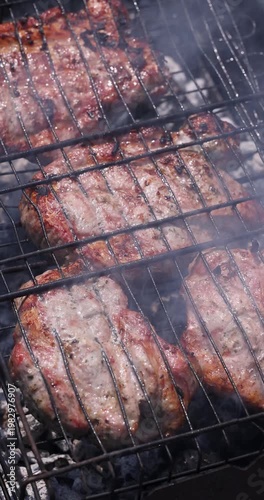 Juicy pork steaks sizzling on bbq grill