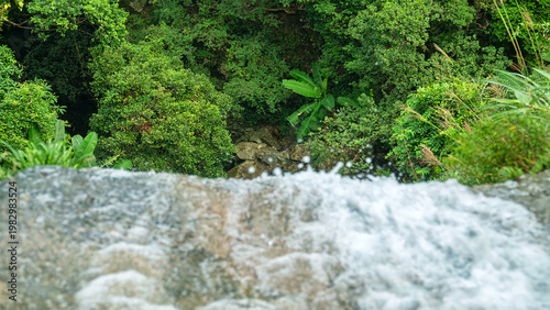 A escarp, ledge, the edges of a waterfall cliff (cataract) and an overhead view of a wet mesohylile forest, at the point of falling water with damp air. Hong Kong Island