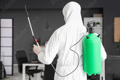 Male worker with disinfecta...