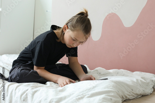 Serious boy using pc tablet and playing. Kid at home