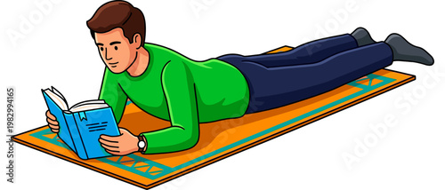 Young man lying on his stomach reading a blue book