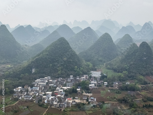Misty hills rise gently behind a quiet village of Yangshuo, Guangxi Province, China
