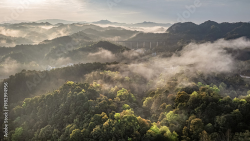 Panoramic view. misty hills rise gently in golden light. China.