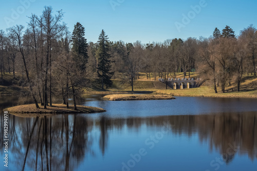 Oranienbaum Spring Sun Park. Still lake mirrors trees and sky
