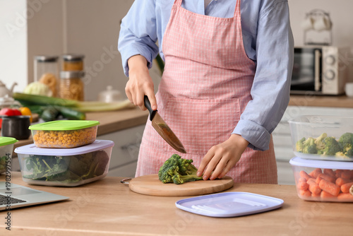 Woman cutting broccoli for ...