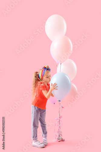 Cute little girl with beautiful balloons blowing kiss on pink background