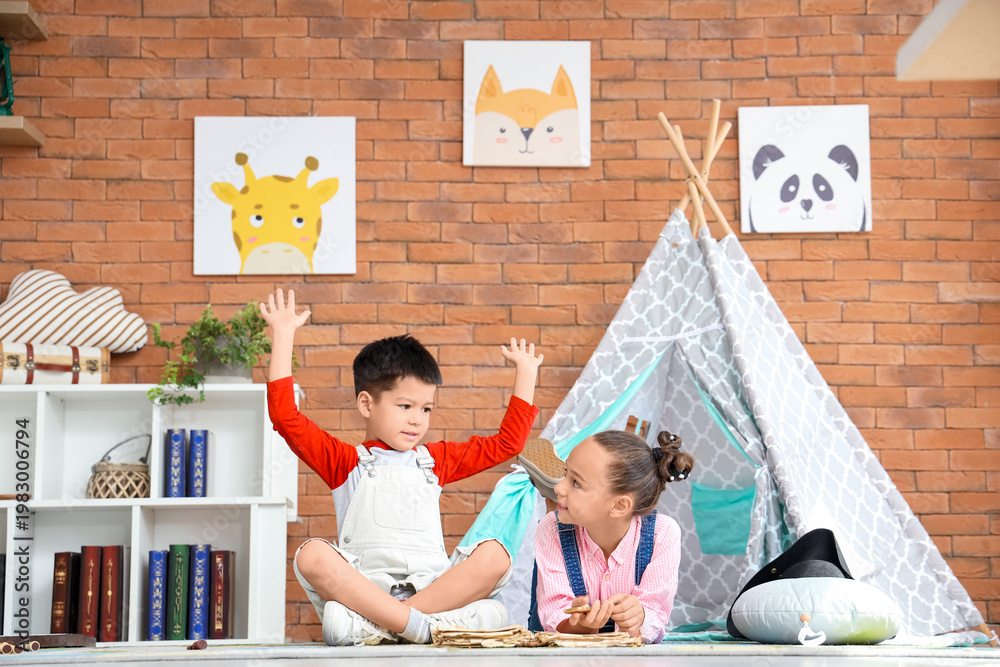 Naklejka premium Cute little children with adventure book at home