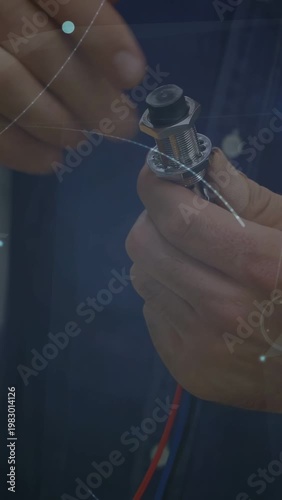 Vertical video: Tech placing lead, securing wire and nut in electronics, ensuring fit amid overlays