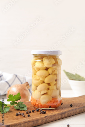 Jar with canned mushrooms on table
