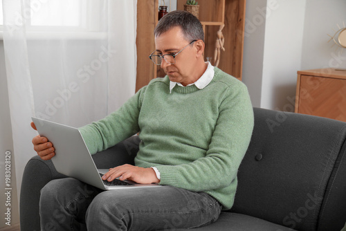 Mature man with laptop mess...
