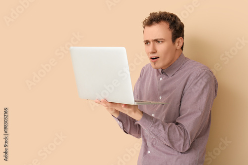 Shocked young man with lapt...