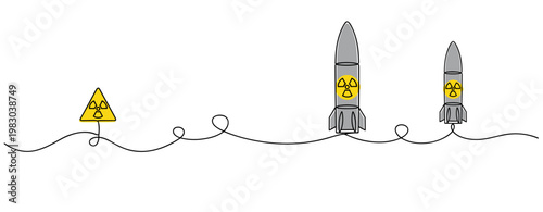 Nuclear missiles standing beside hazard sign on white line