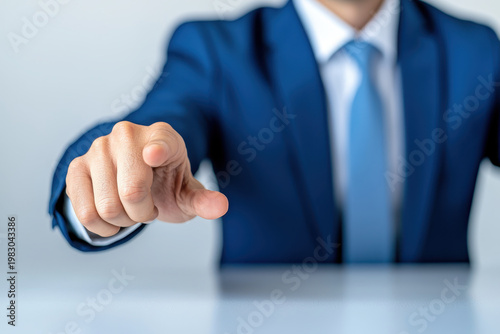 Business manager in blue suit pointing towards viewer, conveying authority and engagement in professional setting