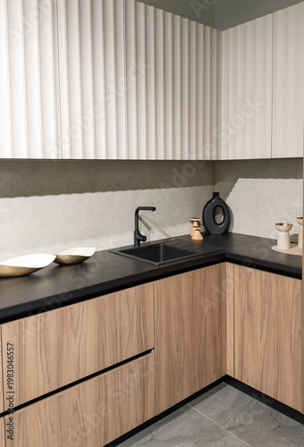 Tableau sur toile Stylish modern kitchen space with wooden cabinets and sleek black countertop des
