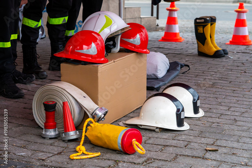 Konstfotografi Firefighting equipment on pavement: professional helmets, rolled fire hoses, noz