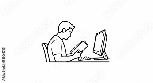Person reading a book while sitting at a desk with a computer