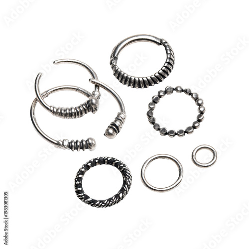Several silver rings with textured designs, arranged against a dark backdrop
