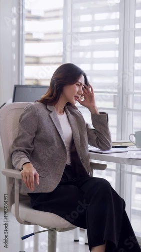 Adult Asian businesswoman experiencing severe headache stress burnout office work pressure overwhelmed employee mental fatigue professional woman corporate environment