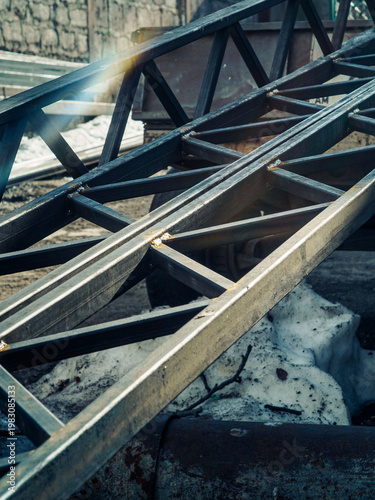 Close-up of industrial steel truss beams with welded joints at a construction site.