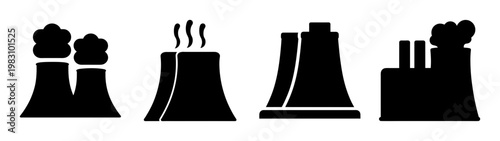 four industrial cooling towers emitting steam at power plant silhouette