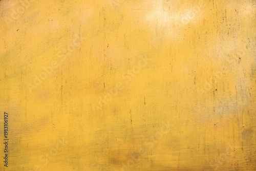 Smooth yellow painted metal surface with subtle wear and grunge marks, suitable for minimal background use.