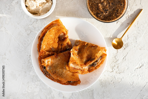 Vegan thin crepes made from banana flours with a filling of cashew ricotta and a plant-based caviar made from chia seeds and nori. Top view.