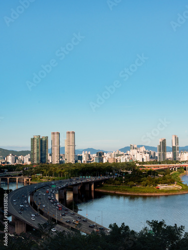 Aerial view of Dongho bridge crossing Han River with residential buildings and mountain background in Seoul.