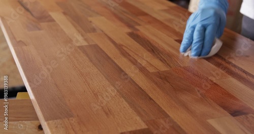 Laminated wood board finished with tung oil using piece of cloth, close up