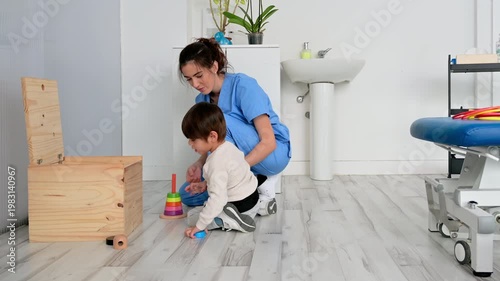 Child with disability performing motor skills exercises with physiotherapist using educational game. Pediatric rehabilitation, coordination development, therapy and healthcare concept. High quality 4k