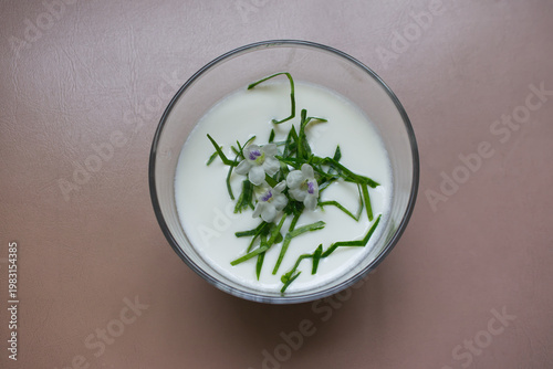 Natural yogurt and chopped kaffir lime leaves are sprinkled on top with flowers