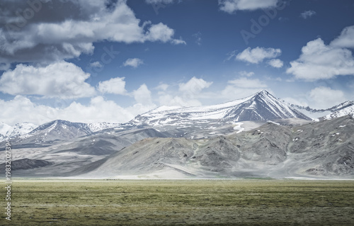 Mountain landscape with a view of a rocky ridge with snow and glaciers in the highlands of Tajikistan in the Pamirs. A panorama of the Tien Shan Mountains for background