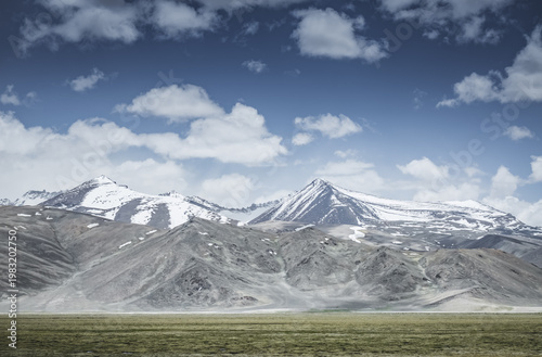 Mountain landscape with a view of a rocky ridge with snow and glaciers in the highlands of Tajikistan in the Pamirs. A panorama of the Tien Shan Mountains for background
