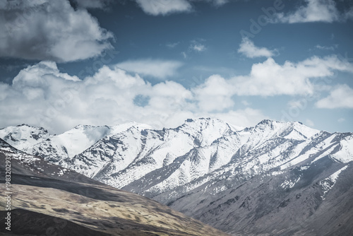 Mountain landscape with a view of a rocky ridge with snow and glaciers in the highlands of Tajikistan in the Pamirs. A panorama of the Tien Shan Mountains for background