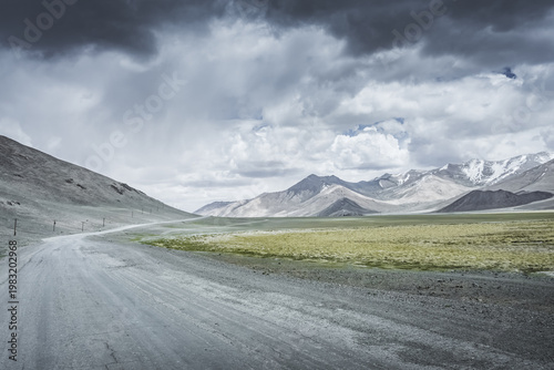 The Pamir Highway in the Tien Shan highlands of Tajikistan, a landscape with a road in the Pamirs, a road stretching into the distance against a backdrop of mountains