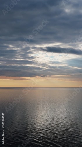 Drone View Of The Baltic Sea As Sunset Approaches With Calm Water, Warm Evening Light, Soft Sky Colors, And Peaceful Horizon Creating Serene And Atmospheric Coastal Aerial Footage
