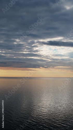 Drone View Of The Baltic Sea As Sunset Approaches With Calm Water, Warm Evening Light, Soft Sky Colors, And Peaceful Horizon Creating Serene And Atmospheric Coastal Aerial Footage
