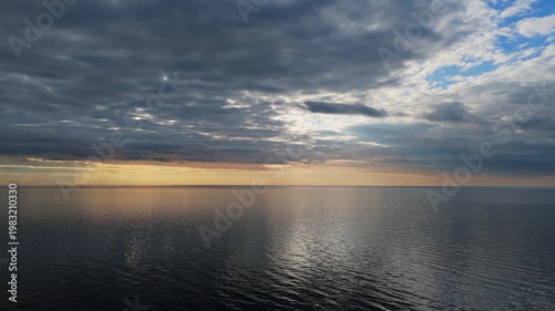 Drone View Of The Baltic Sea As Sunset Approaches With Calm Water, Warm Evening Light, Soft Sky Colors, And Peaceful Horizon Creating Serene And Atmospheric Coastal Aerial Footage
