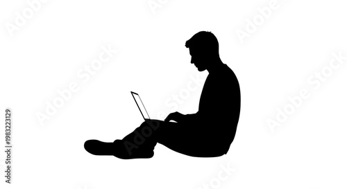 Silhouette of a man sitting on the floor and working on a laptop