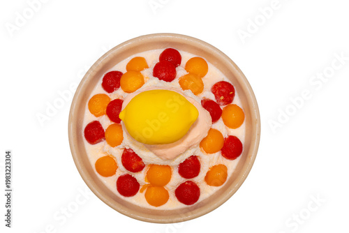 A refreshing bowl of fruit bingsu featuring shaved ice, melon and watermelon scoops, topped with a lemon-shaped dessert and Pocky.