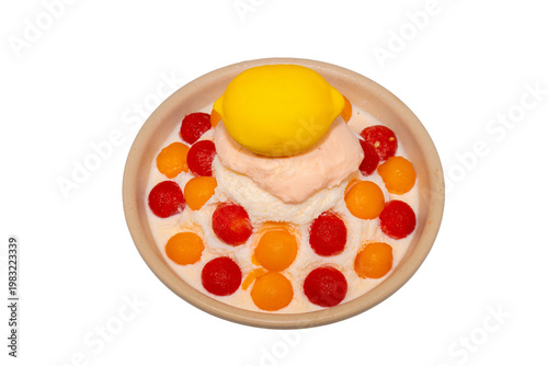 A refreshing bowl of fruit bingsu featuring shaved ice, melon and watermelon scoops, topped with a lemon-shaped dessert and Pocky.