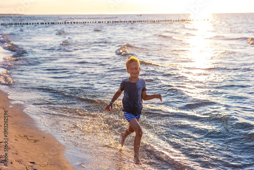 Photography Child runs shallow sea water sunset splashing waves sunlight reflects surface creates warm summer mood
