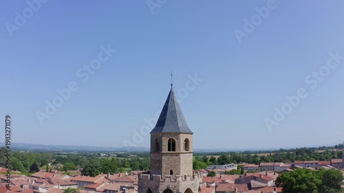Aerial View of Stone Church Tower Above Village Rooftops and Horizon